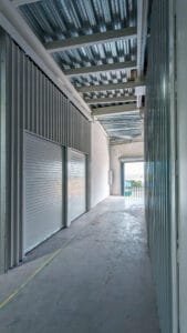 Esquina interior de una minibodega nueva, mostrando la unión del piso de concreto y los muros metálicos