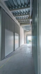 Esquina interior de una minibodega nueva, mostrando la unión del piso de concreto y los muros metálicos