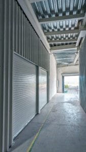 Interior de una minibodega limpia con piso de concreto pulido y muros de lámina, lista para almacenamiento.