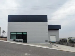 Fachada exterior de nave industrial de manufactura con 225KVAs disponible en parque industrial seguro.