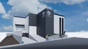 Render exterior de una nave industrial con diseño contemporáneo, mostrando su área de oficinas y el acceso a la bodega.